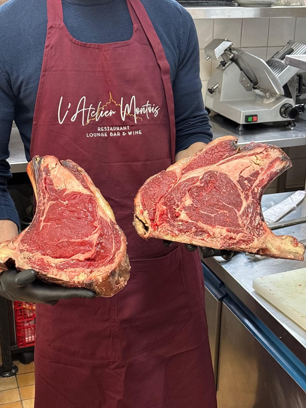 The chef holding two dry-aged ribs of beef