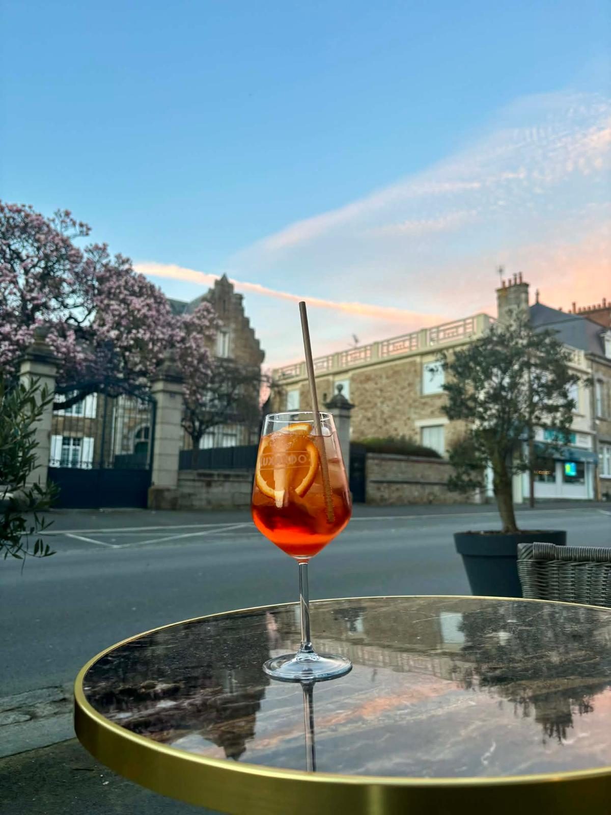 The terrace of L'Atelier Montois at sunset, a spritz on the table